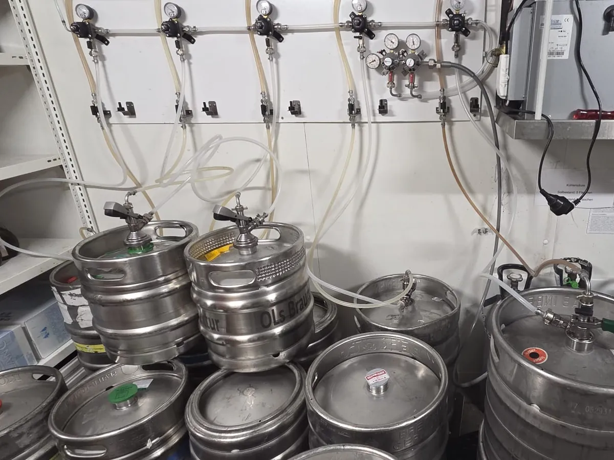 Bierkeller mit Fässern, Druckminderern und CO₂-Leitungen – professionelle Wartung der Schankanlagen-Technik